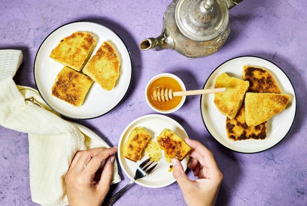 Gluten-free harcha Moroccan flatbread made with corn flour served with honey butter for authentic healthy breakfast, showcasing traditional adapted recipes for celiac-safe morning meals