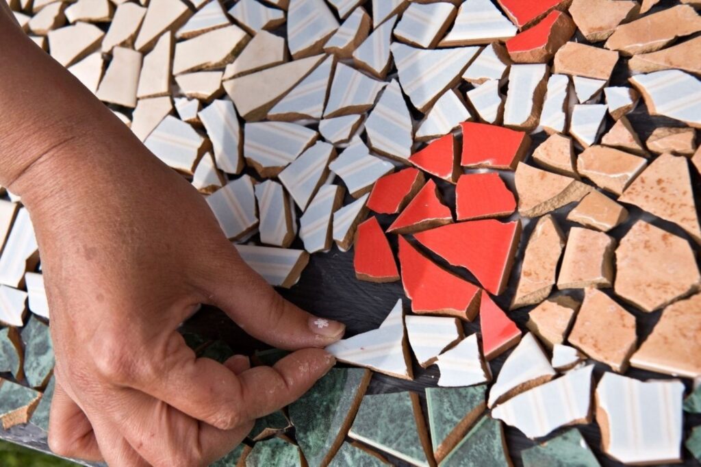 Projet de carrelage marocain DIY avec des mains créant des motifs décoratifs d'inspiration zellige à la maison