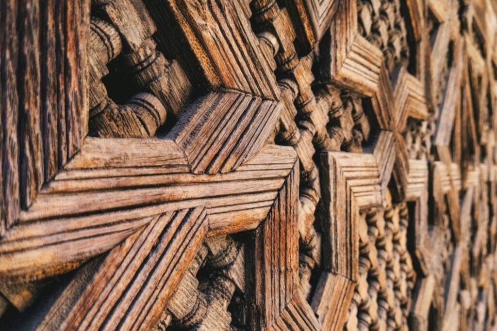Restauração de portas marroquinas mostrando detalhes de entalhe em madeira tradicional e padrões geométricos históricos