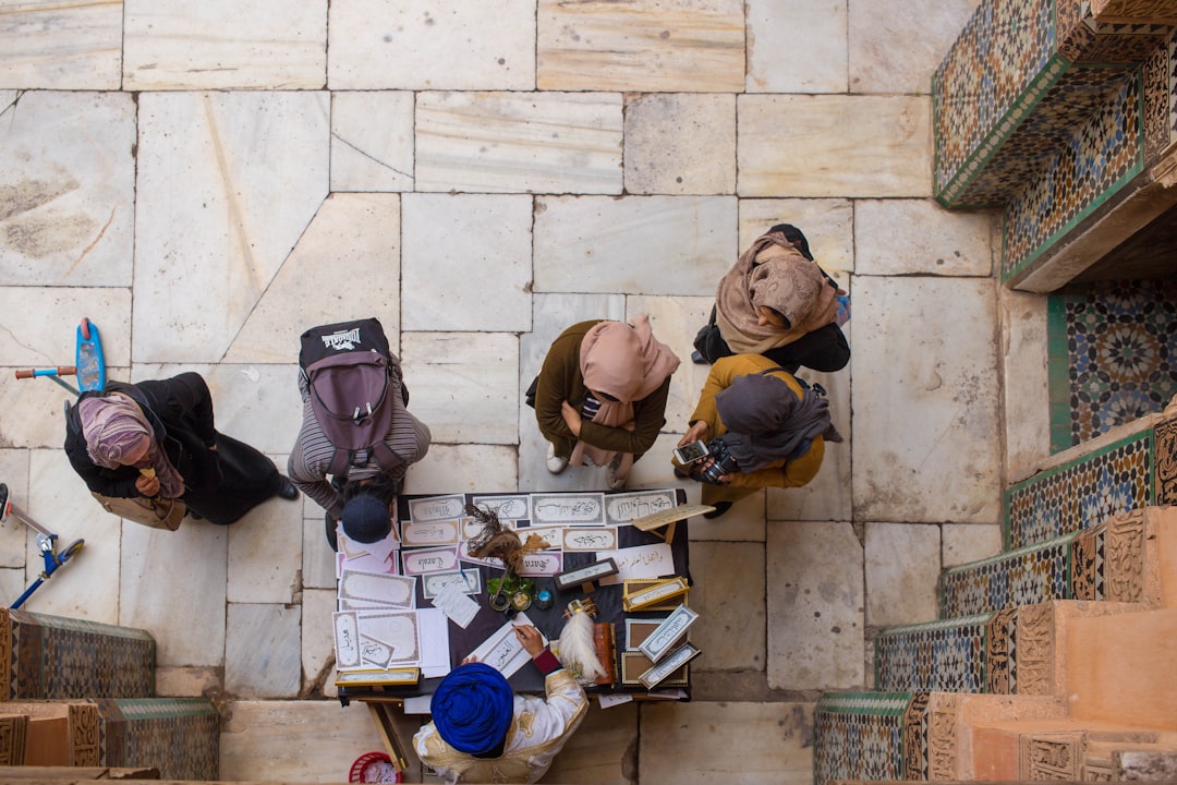 Une femme admirant un mur de zellige aux couleurs éclatantes dans la cour d'un riad marocain traditionnel
