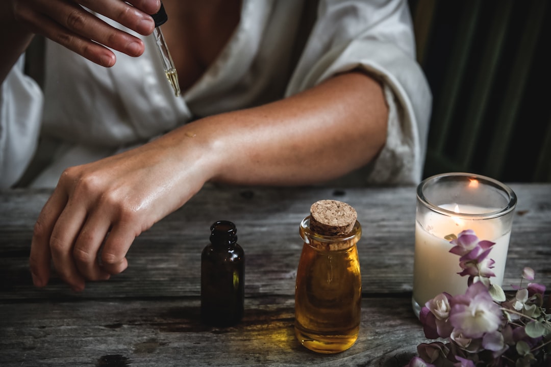 Uma mulher aplicando óleo de argan como parte de sua rotina de cuidados com a pele para proteção solar e recuperação