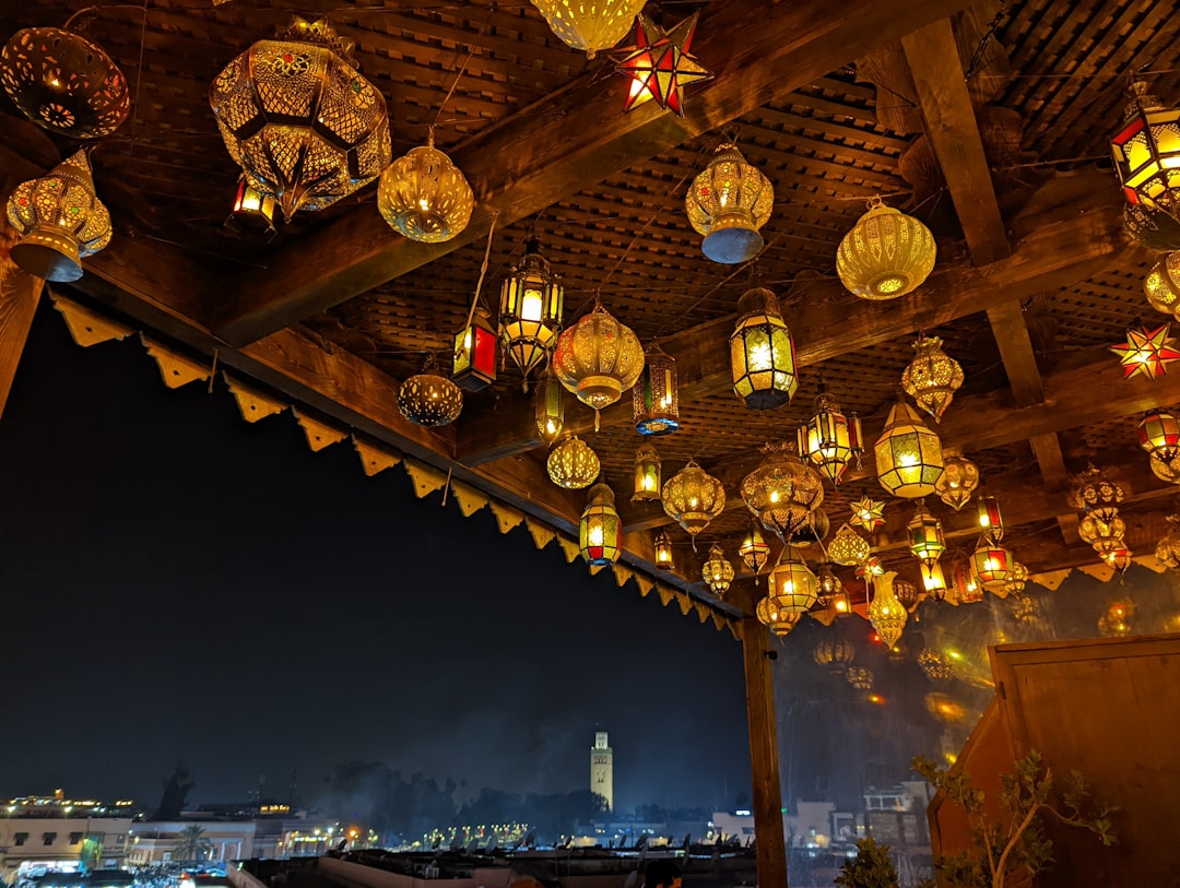 A traveler seated on a rooftop terrace at private riads in Morocco watching the Atlas Mountains at dusk