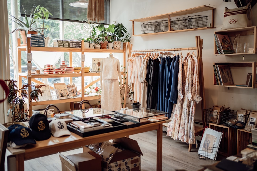 Uma mulher explorando uma boutique de moda marroquina feita eticamente, cercada por roupas de verão de tecidos naturais.