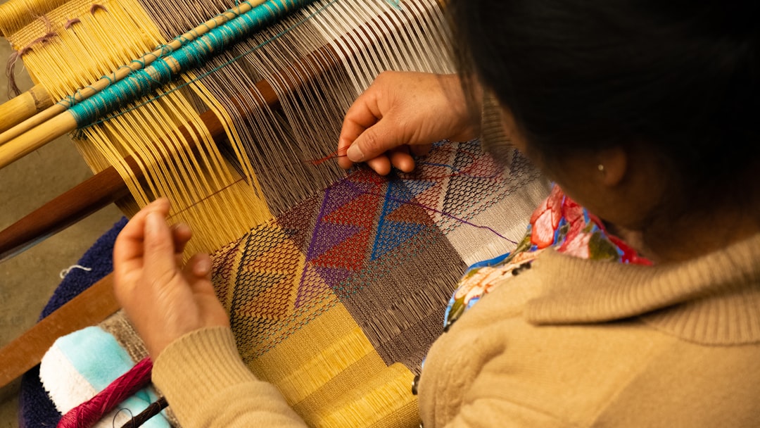 Um artesão marroquino habilidoso tecendo tecido à mão em uma oficina na medina, uma prática central da moda sustentável marroquina.