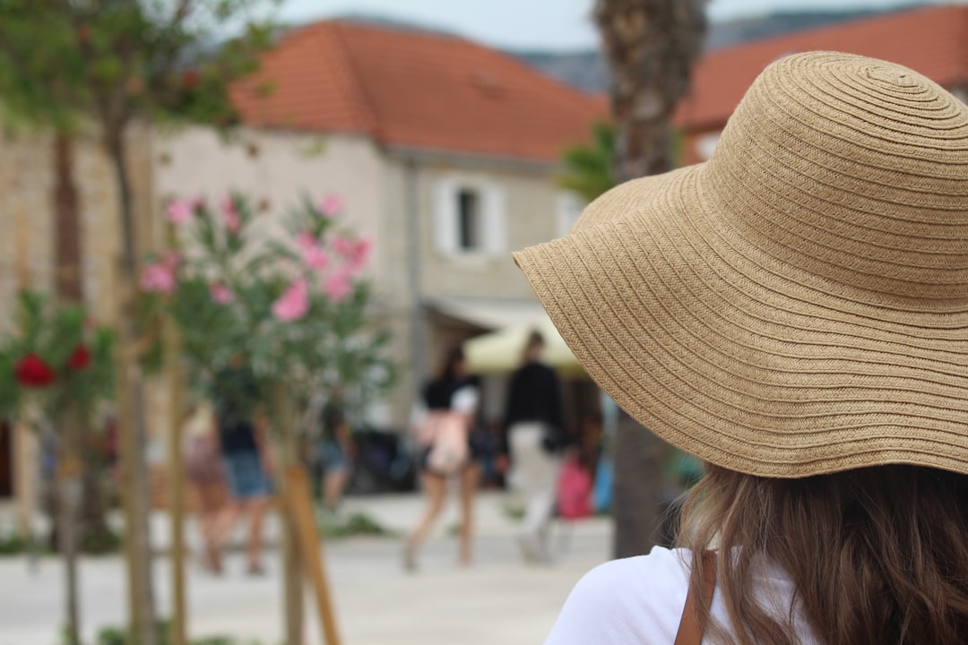 Uma mulher usando um chapéu de abas largas para proteção solar enquanto caminha por um mercado marroquino