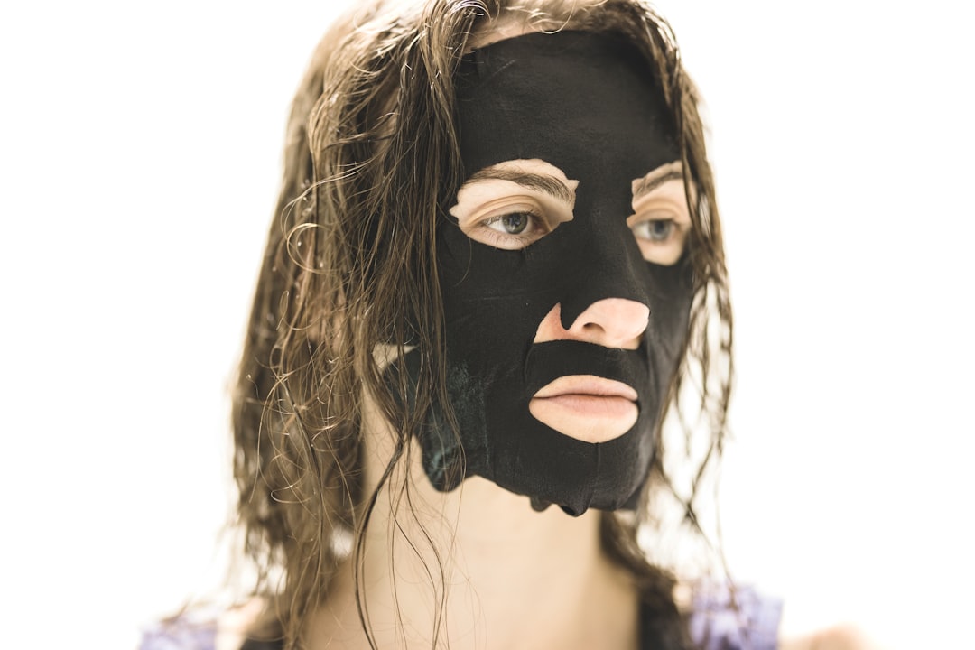 A woman applying a rhassoul clay mask to her scalp, a key step in an argan oil summer haircare routine