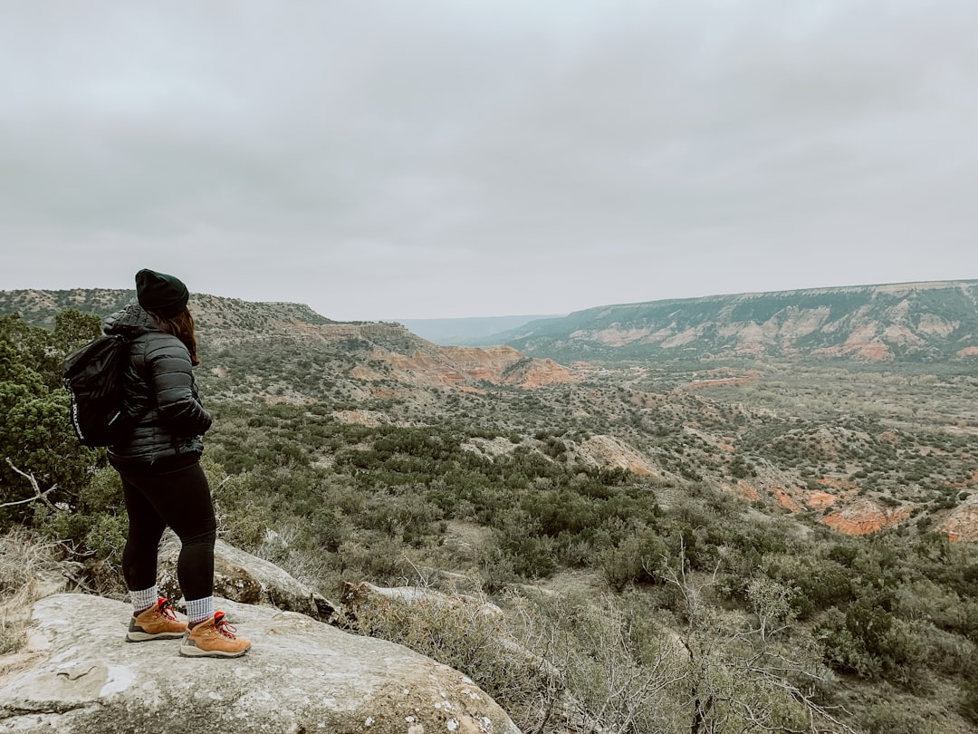 Uma mulher desce uma trilha rochosa na montanha perto de Azilal através de um desfiladeiro estreito no Marrocos