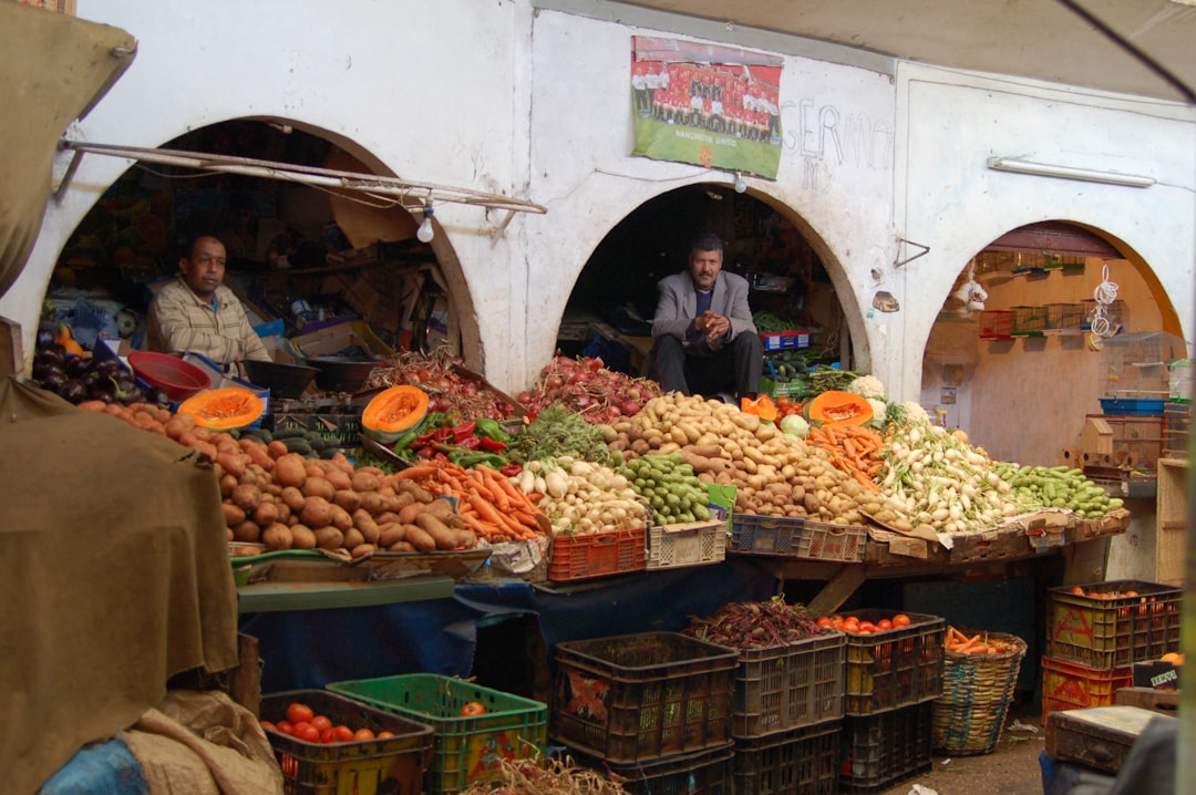 Um homem navegando por vegetais frescos e azeitonas em um souk marroquino, ideal para comer sem glúten nos festivais do Marrocos
