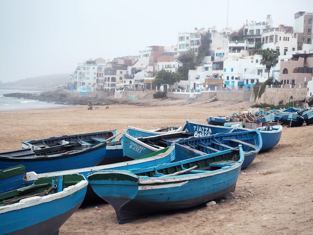 A surfer walks through a narrow street in one of Morocco's coastal medinas after a morning session on the Atlantic