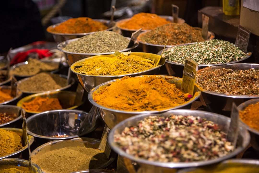 A spice vendor in a Marrakech souk surrounded by vibrant colours, showing the sensory richness of Moroccan food culture.