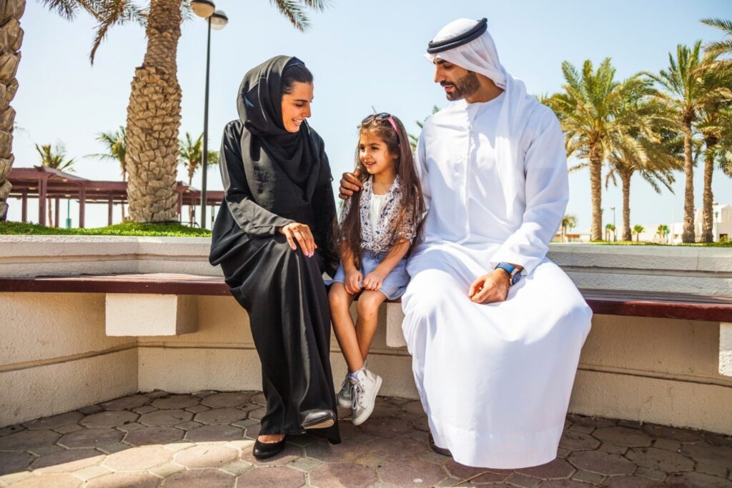 Emirati family sitting with daughter in park Dubai confident kids resilient parenting emotional mindful