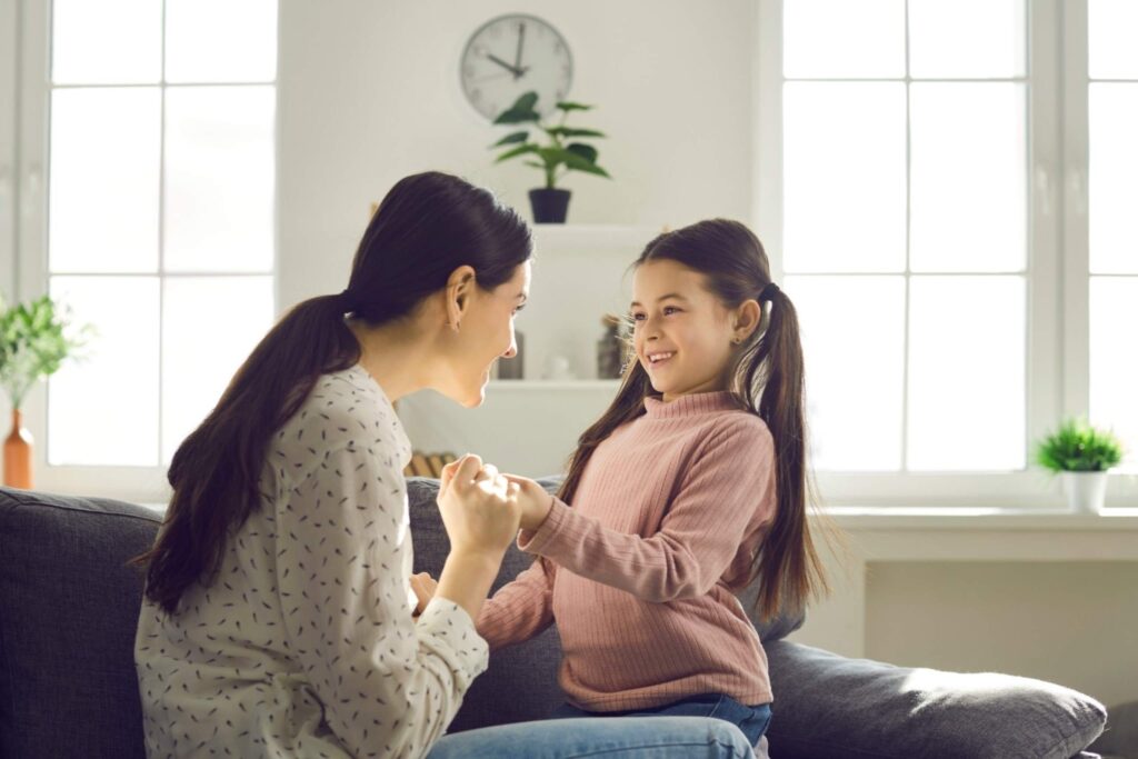 Mother having conversation with young daughter at home confident kids emotional parenting resilient mindful