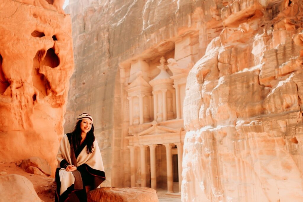 Tourist exploring ancient Petra archaeological site in Jordan weekend escapes adventure travel flight