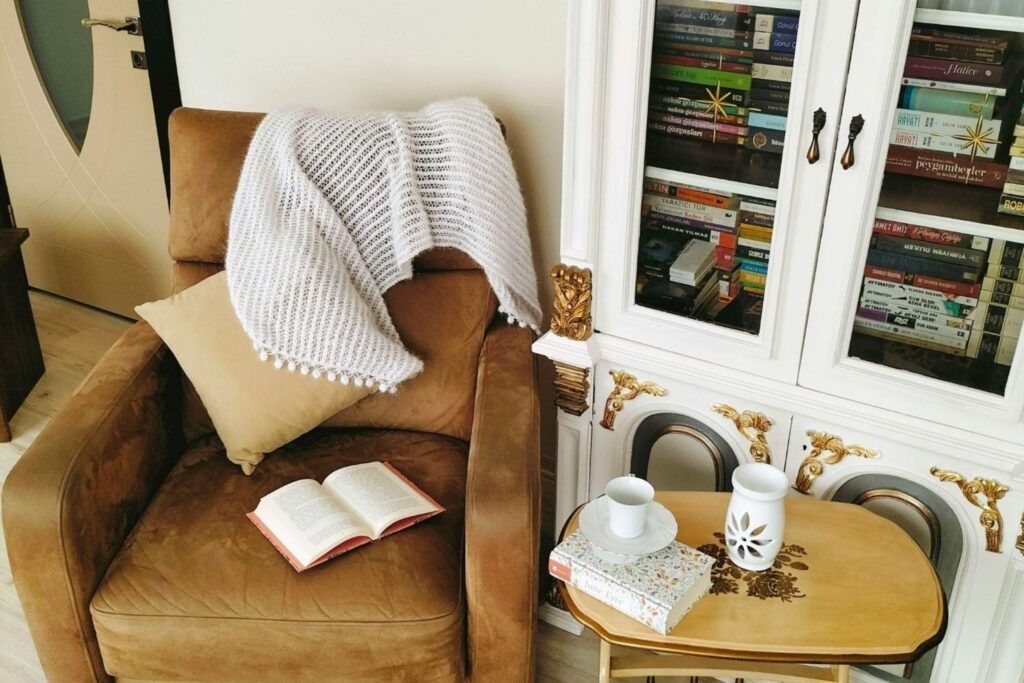 Comfortable reading nook with chair blanket and warm lighting cosy living home comfort hygge warm
