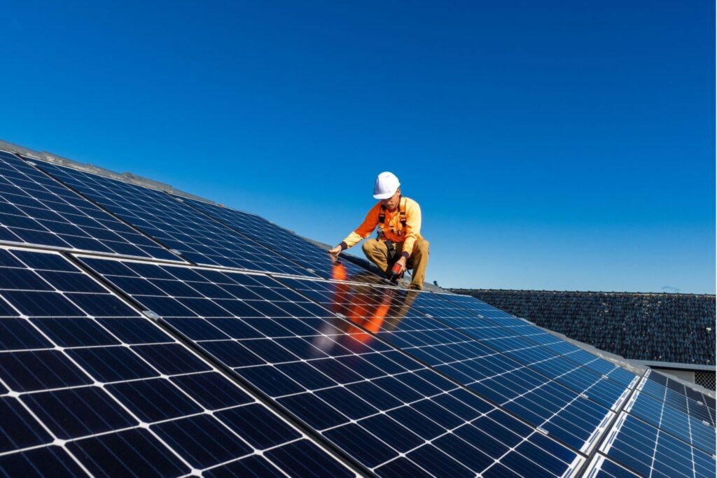 Technician installing solar panel system on rooftop solar power renewable energy sustainable DEWA