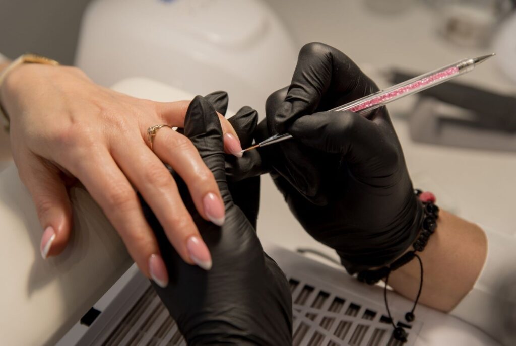 Professional nail technician creating beautiful nail art at affordable beauty spots in Dubai, demonstrating quality budget-friendly services perfect for students and young women seeking value