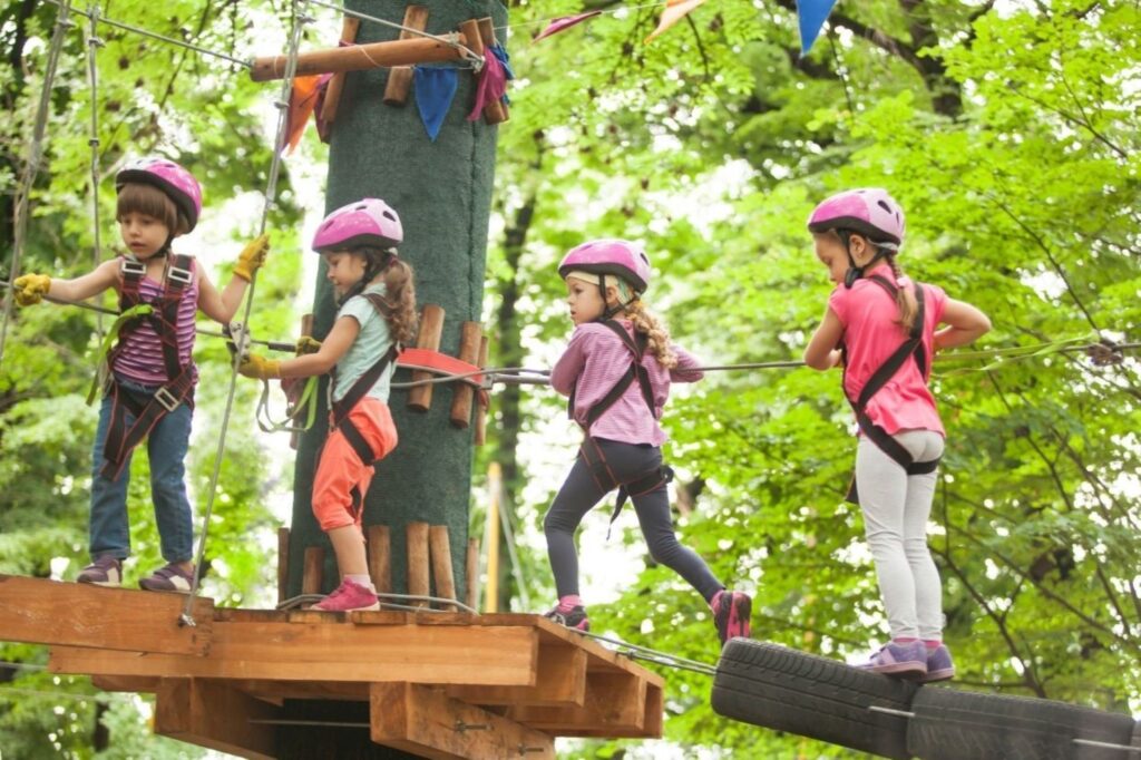 Kids exploring nature-based school holiday activities at Aventura Parks Dubai in Ghaf tree forest, demonstrating outdoor education camps with zip-lining, survival skills, and environmental learning