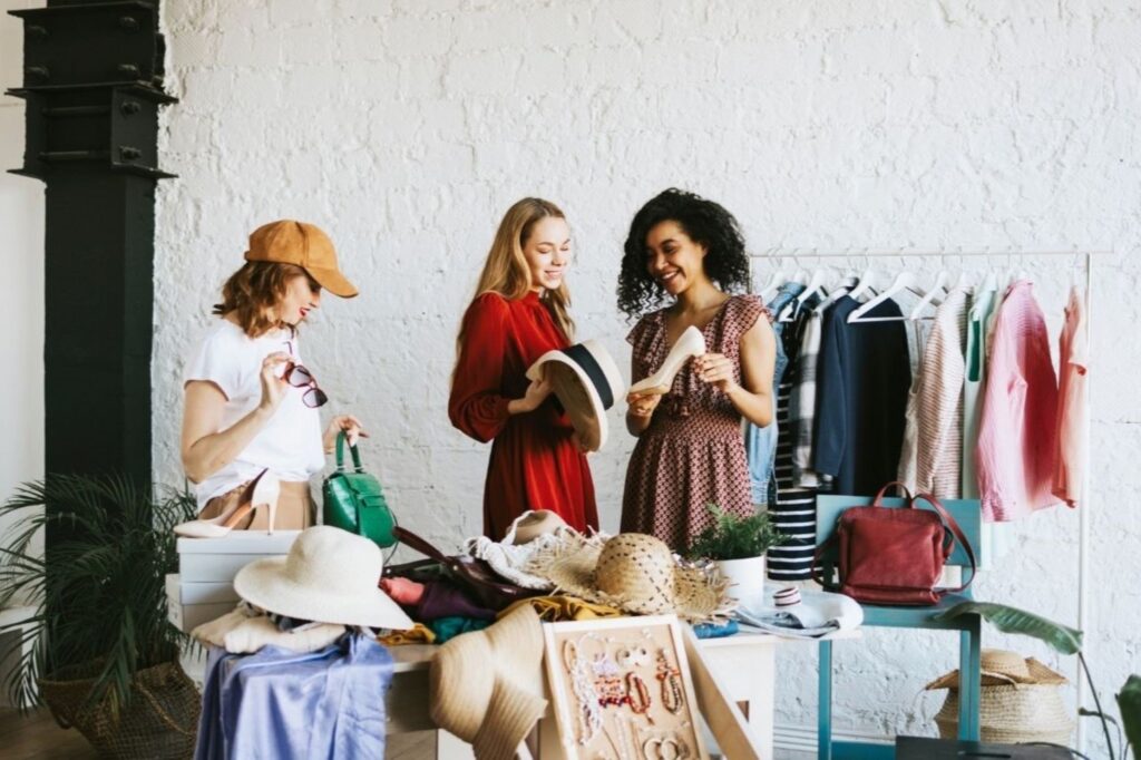 Women browsing sustainable party wear at eco-friendly fashion boutique in Dubai, showcasing ethical shopping experience with organic fabrics and artisan-made celebration clothing