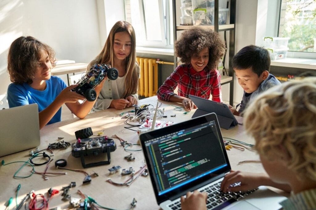 Young students participating in STEM robotics and coding school holiday activities in Dubai, showcasing educational technology camps teaching AI, programming, and innovation during winter break