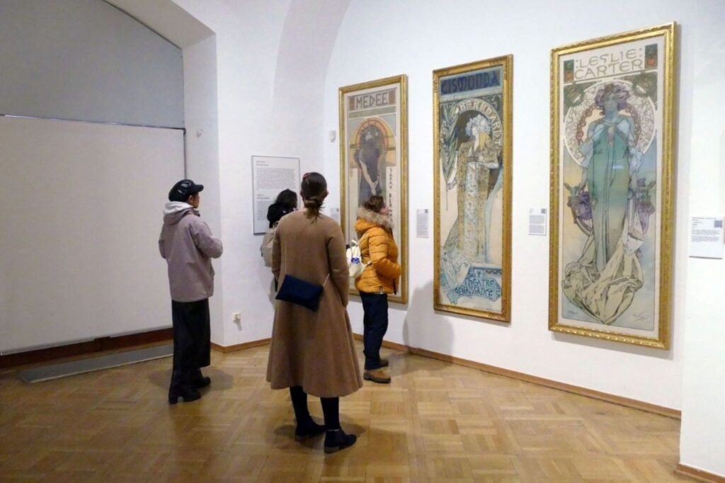 Art Dubai collectors examining artworks with gallery representative during visitor guide experience at fair