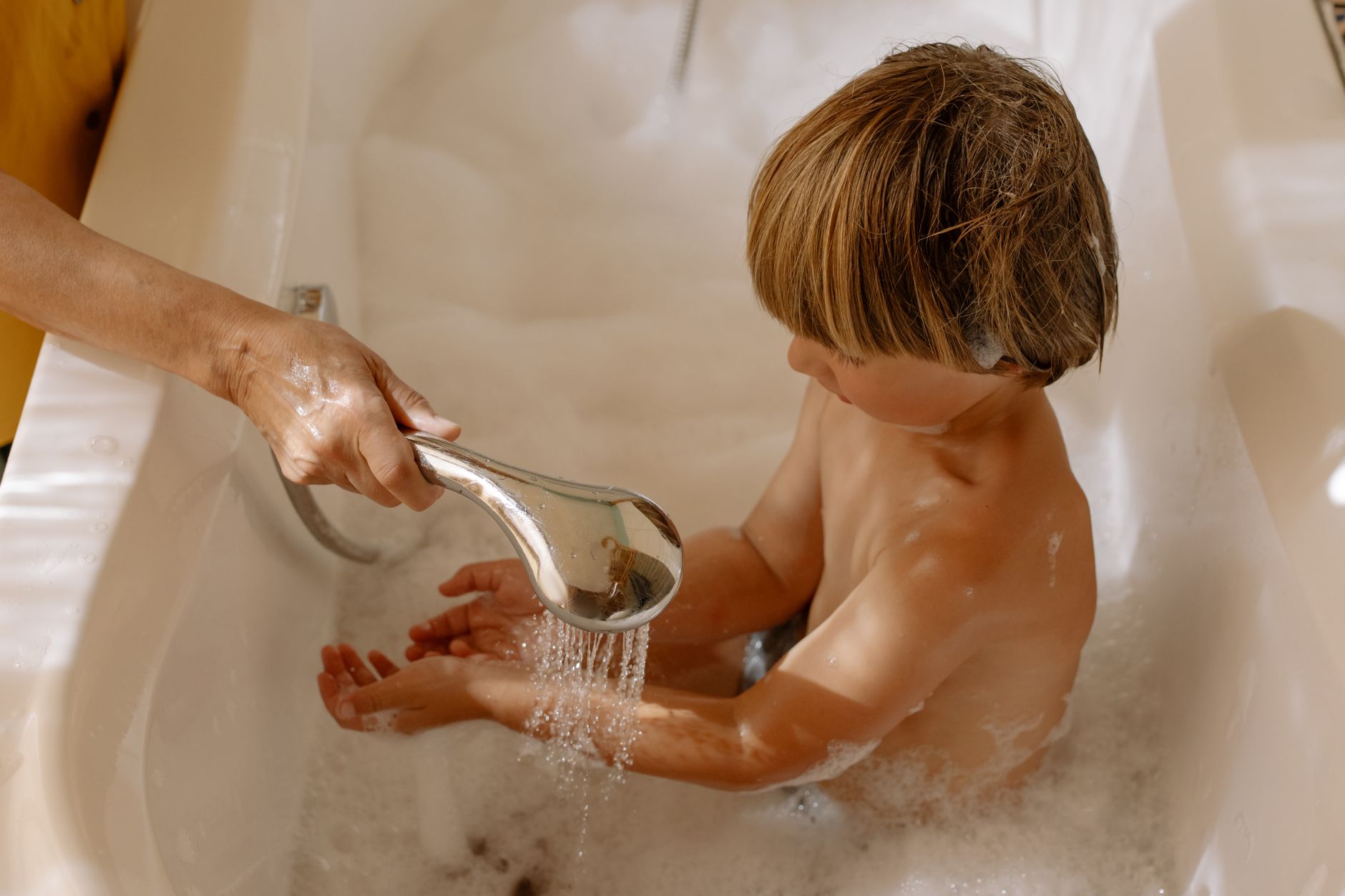 A person fitting a low-flow showerhead as a practical step to lower water use at home in Dubai
