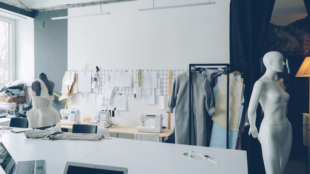 A fashion designer works in a Dubai studio, hand-stitching a slow fashion garment from natural organic fabric.