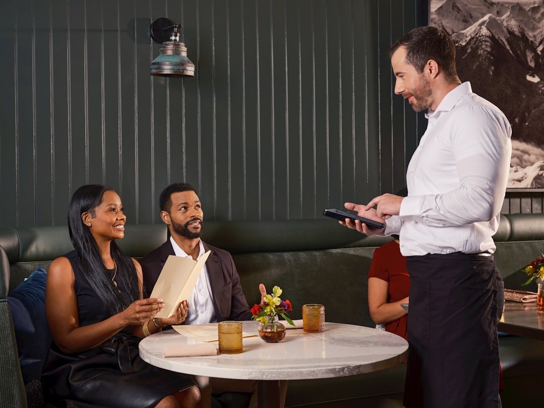 A couple using a phone to book their summer restaurant week table at a Dubai restaurant