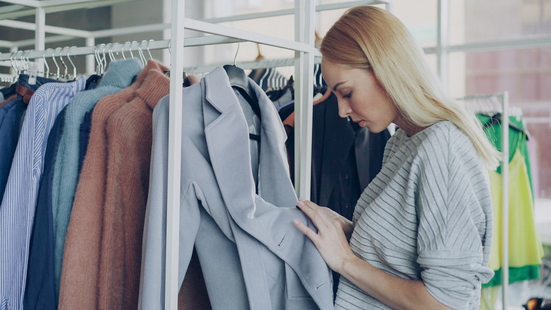 A woman laying out a curated capsule collection, a core step in creating a sustainable wardrobe with intention and care.