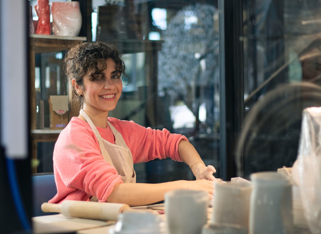 A woman shapes clay during a hands-on ceramics workshop, one of many art residencies and creative studio programmes in Dubai