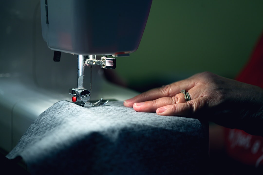 A woman repairing a garment at home, extending the life of her sustainable wardrobe and reducing textile waste.