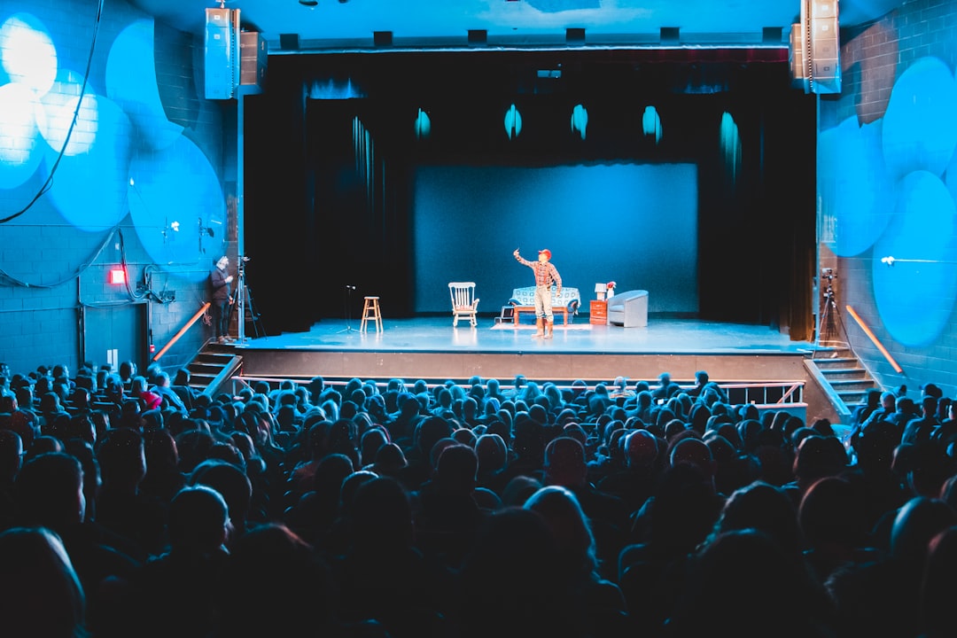 Engaged audience members watch an Arabic theatre show at an intimate Dubai venue during the summer season.