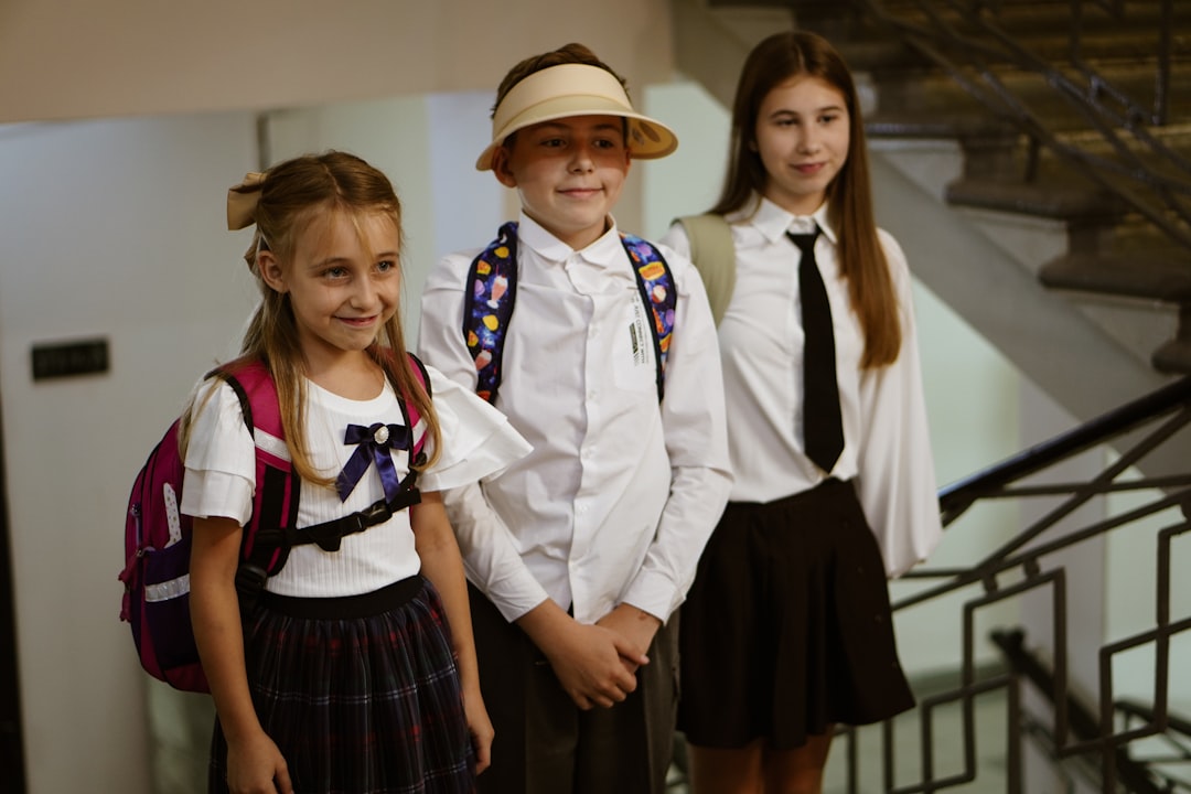 Three children in school uniform eating breakfast as part of their morning school term routine in Dubai