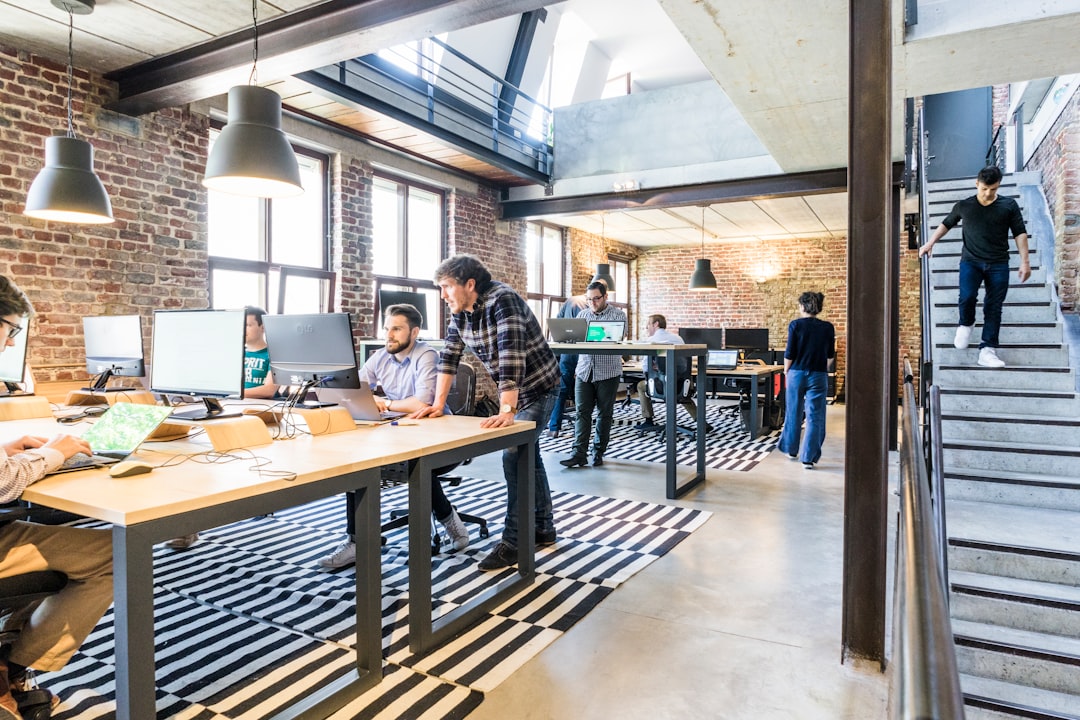 Two entrepreneurs in conversation inside a modern co-working space in Dubai, reviewing documents at a shared table.