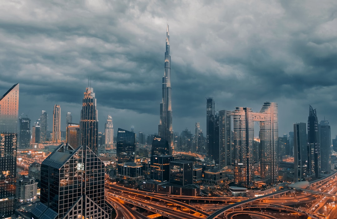 African tech startup founder works on a laptop with the Dubai skyline visible behind them, reflecting the city's appeal.