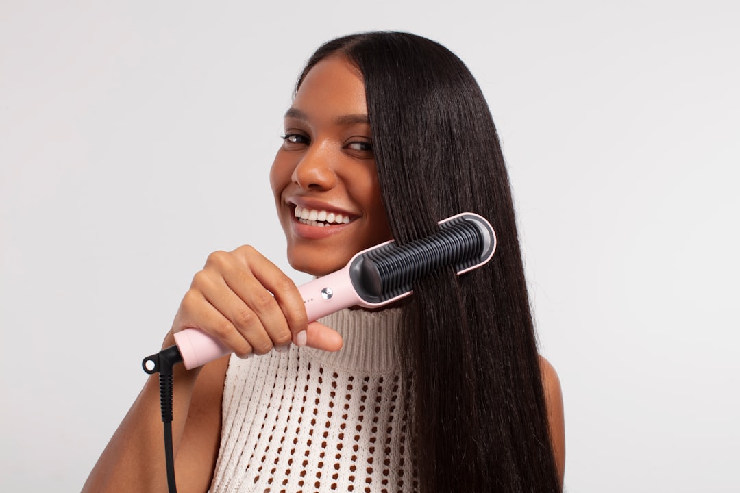 A stylist applying a bond repair treatment to a client with heat damaged hair in a Dubai salon
