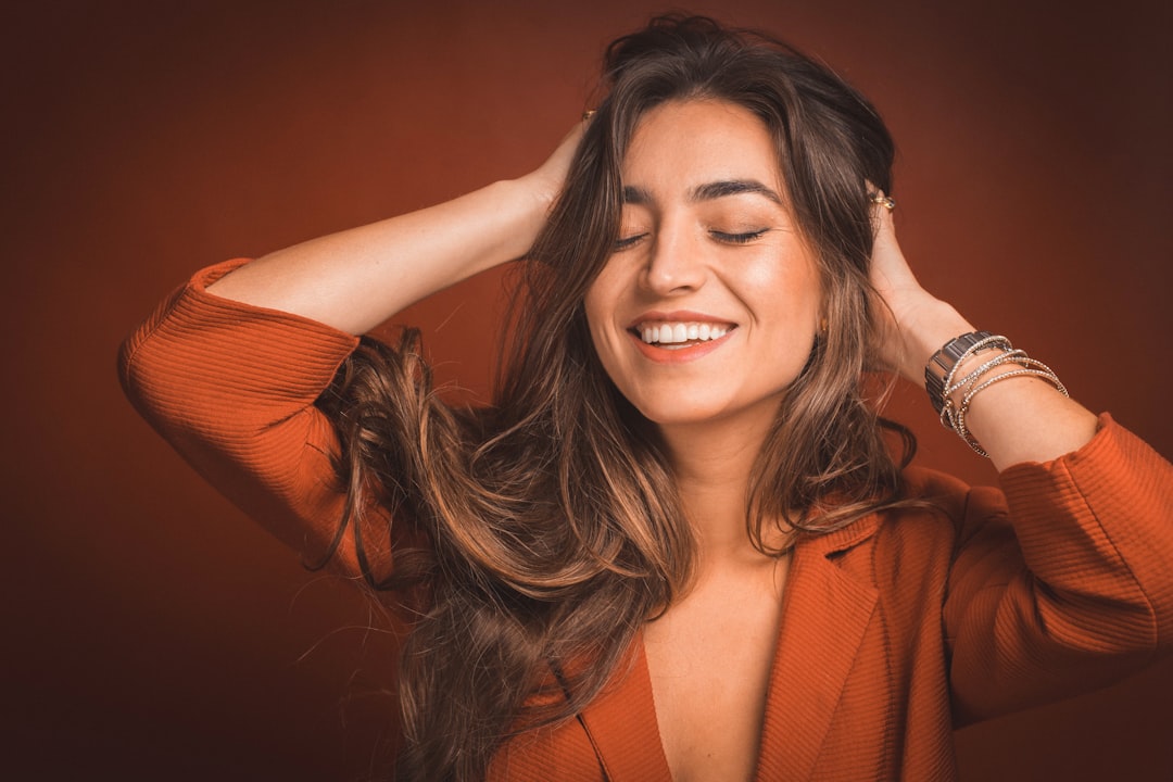 A woman with restored, shiny strands after treating heat damaged hair before a Dubai autumn event