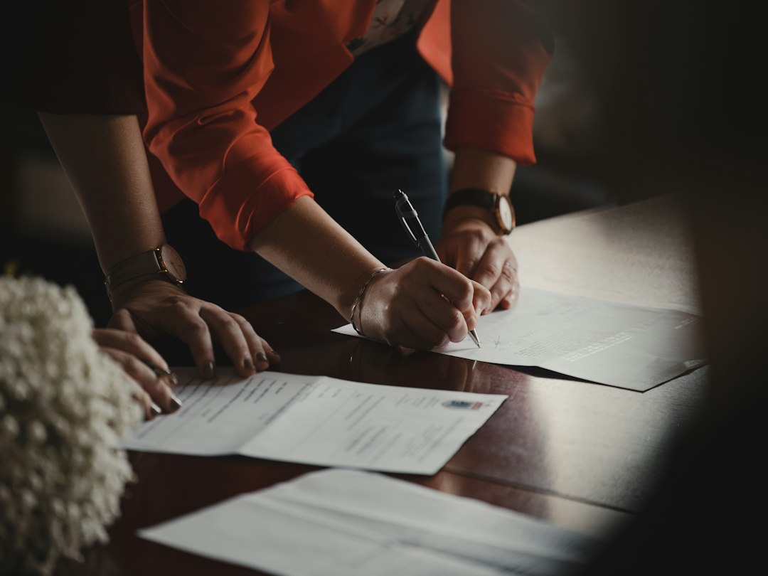 A professional signs paperwork to complete his Dubai business license registration at a free zone authority
