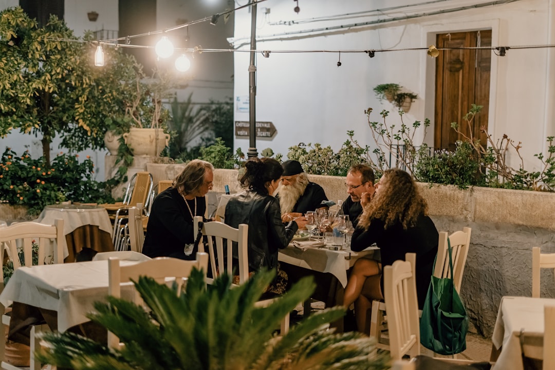 A group of friends sharing dishes at an outdoor table, capturing the joy of terrace dining in Dubai
