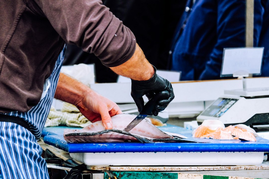 Vendor arranging fresh catch at a Dubai seafood market counter