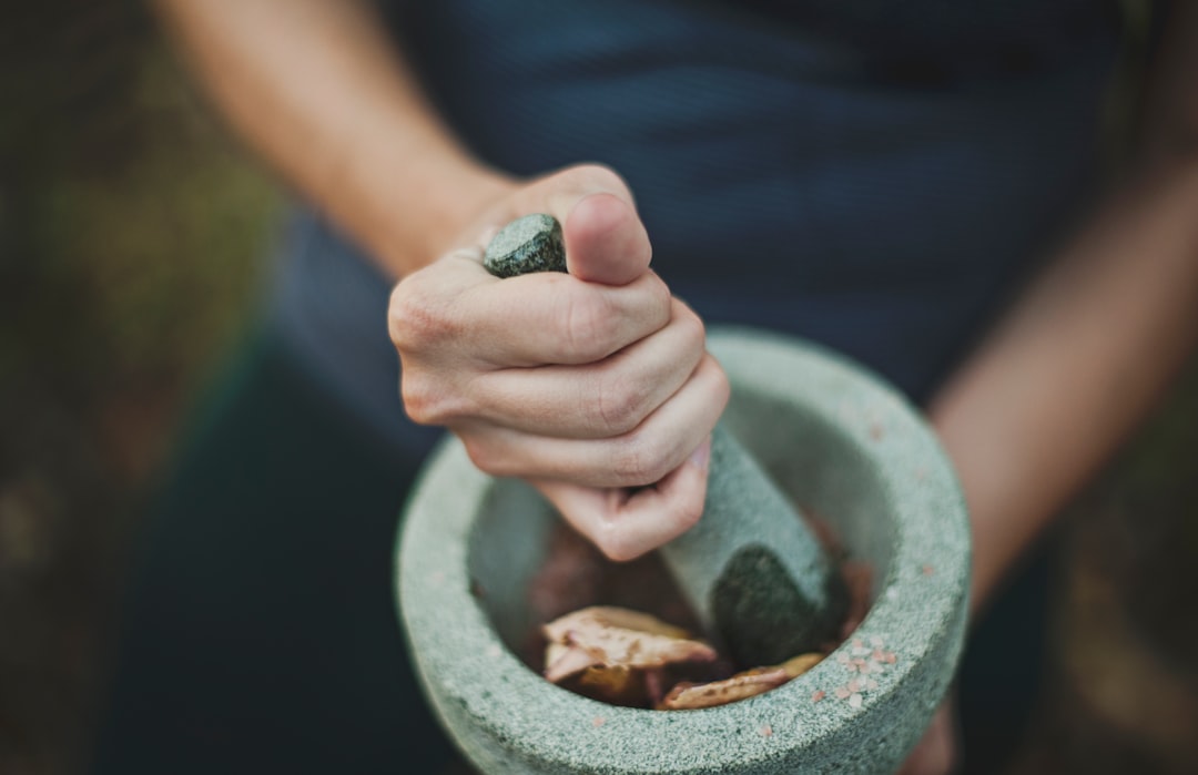 A chef grinds rempah spice paste by hand, a core technique in authentic Peranakan cuisine