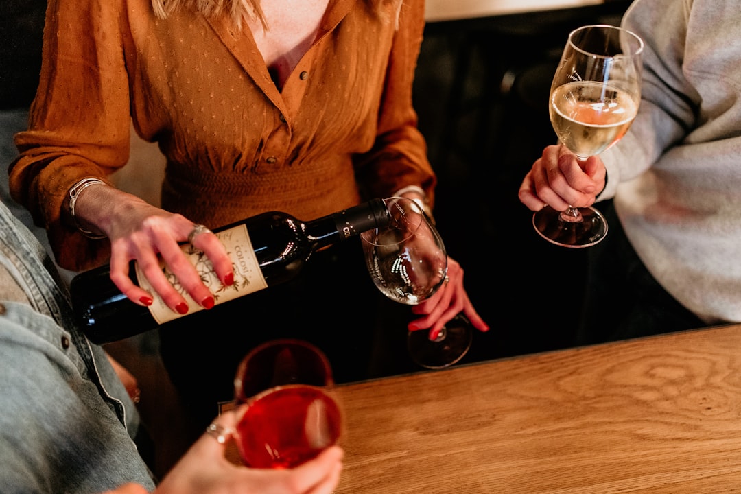 A couple selects a bottle from a walk-in private cellar in Singapore, guided by a wine professional