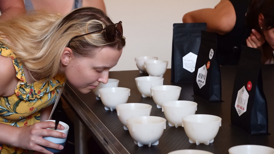 A coffee judge evaluates a cup during a Singapore coffee specialty competition, assessing flavour, aroma, and consistency