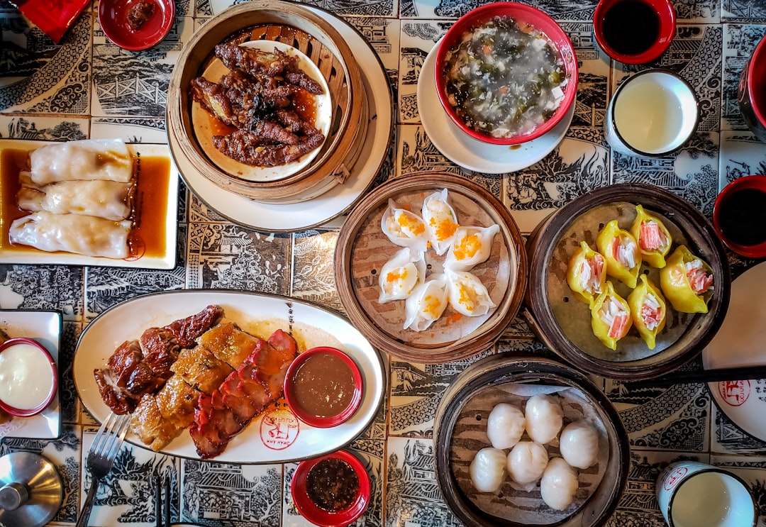 Friends sharing plates of plain rice and grilled seafood at a Singapore gathering, enjoying a gluten-free meal together