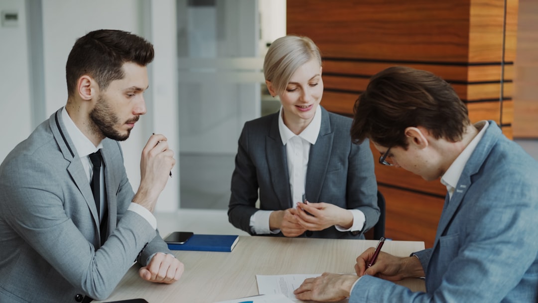 A couple discussing buy-to-let mortgage options with a broker in a London financial office
