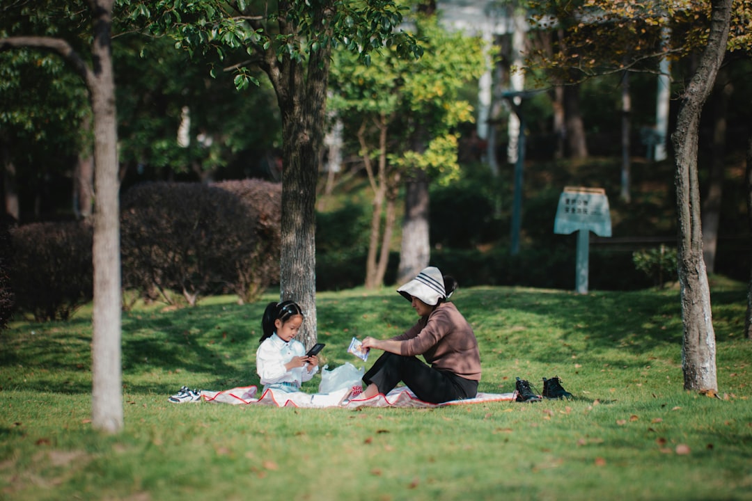 A mother and her children enjoying a picnic lunch together in one of London's beautiful parks during summer