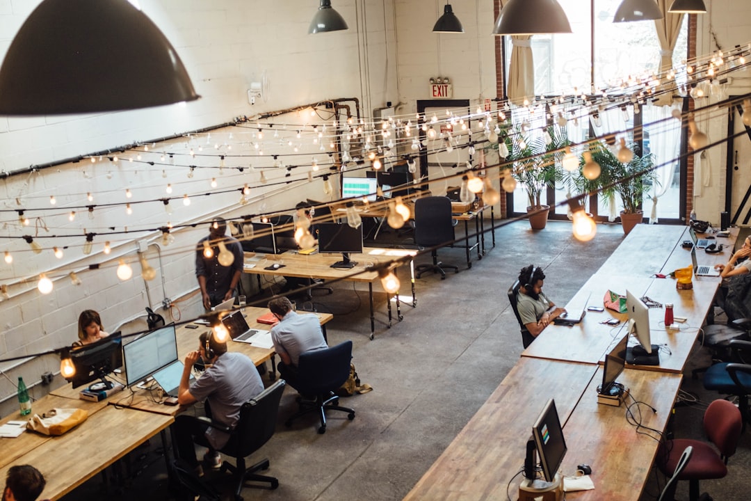 A startup founder networking with colleagues at a co-working desk in a London business hub