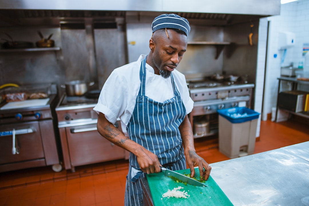 A chef from the Ghanaian community plates traditional food inside a busy London restaurant kitchen