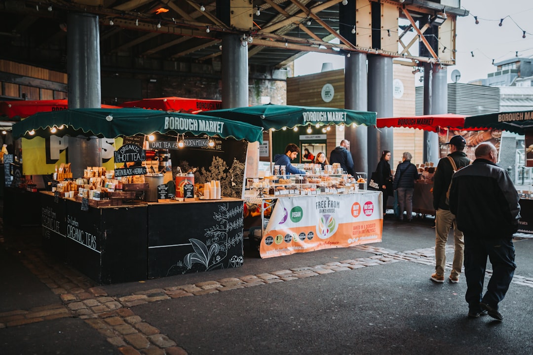 Friends eating street food at Borough Market as part of a budget London trip