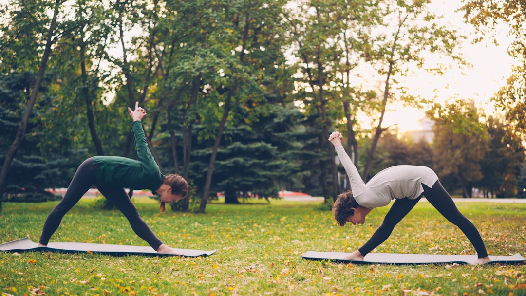 A person doing gentle stretching in a London park as part of a cool morning routine before peak heat hours