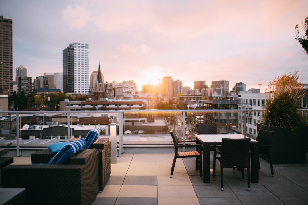 drinks at a rooftop bar as the sun sets over the London skyline behind.